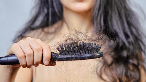Woman losing hair and a hairbrush